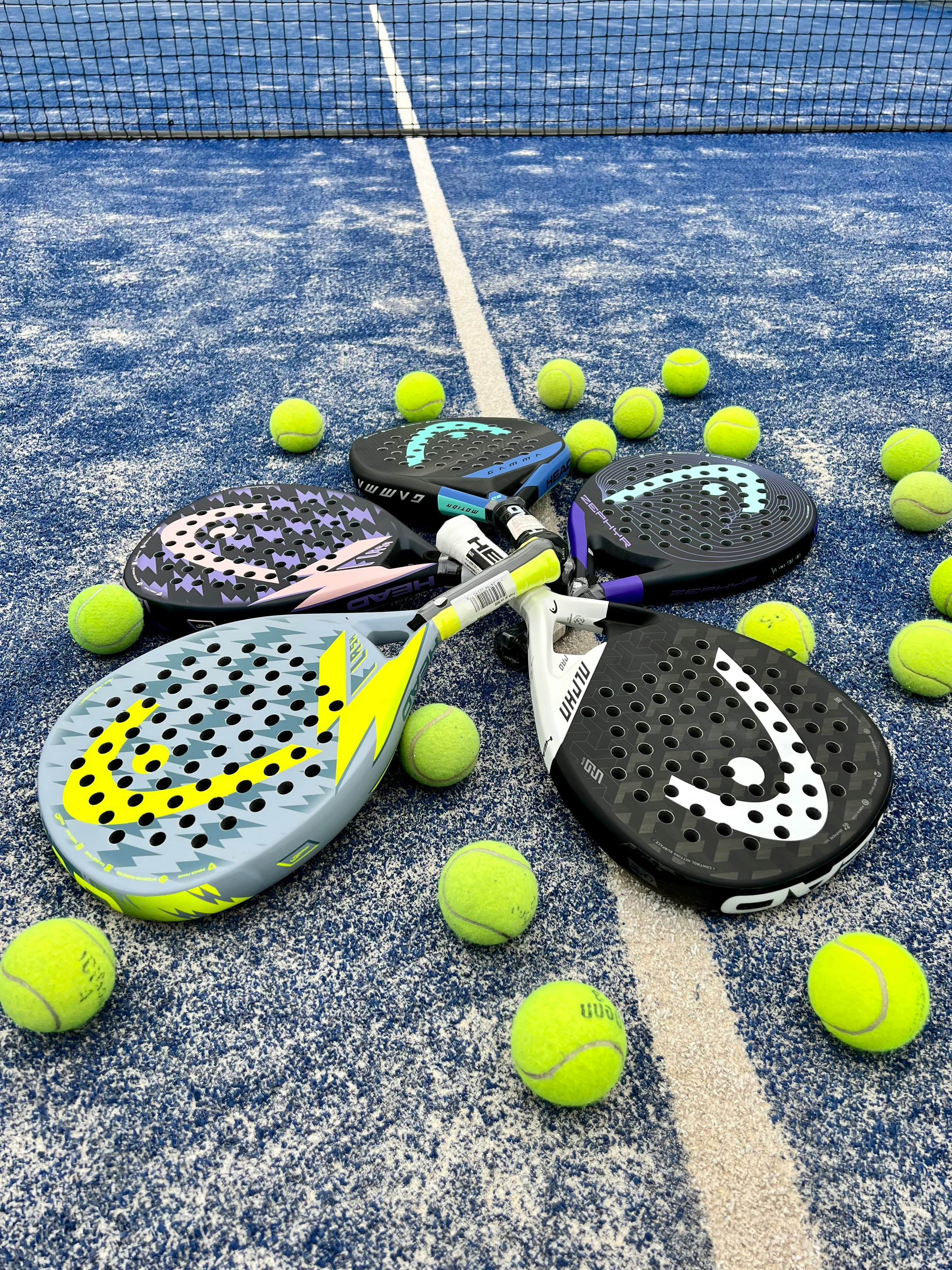 Padel rackets and tennis balls on a blue court